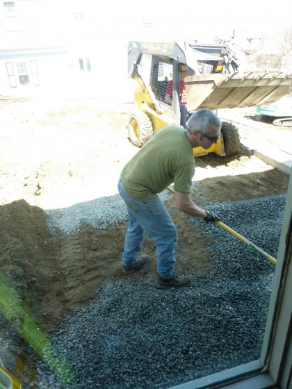 gravel gets spread for patio bed