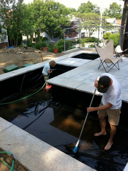 the boys spray down the pond liner